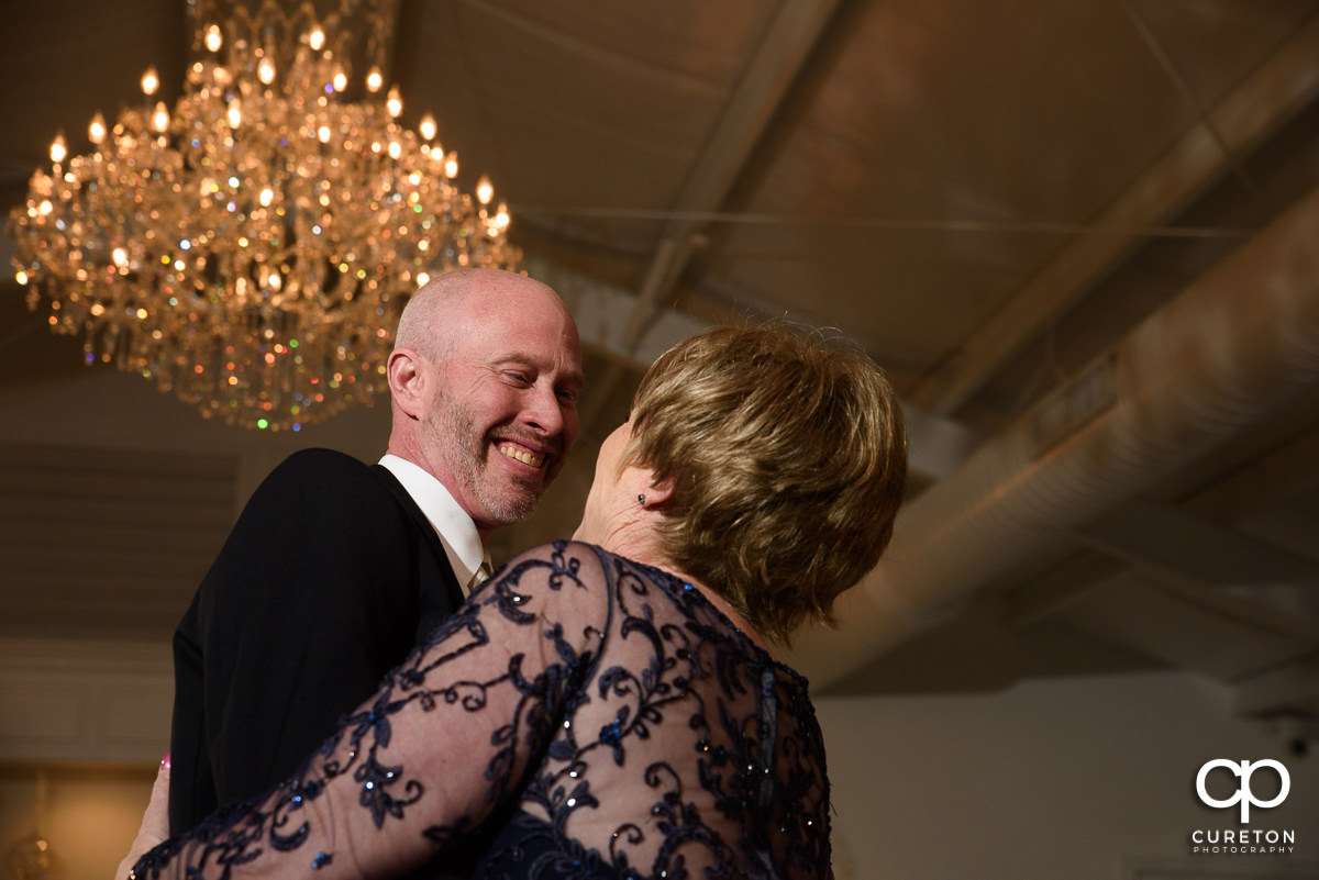 Groom smiling at his mother while they dance during the Ryan Nicholas Inn wedding reception.