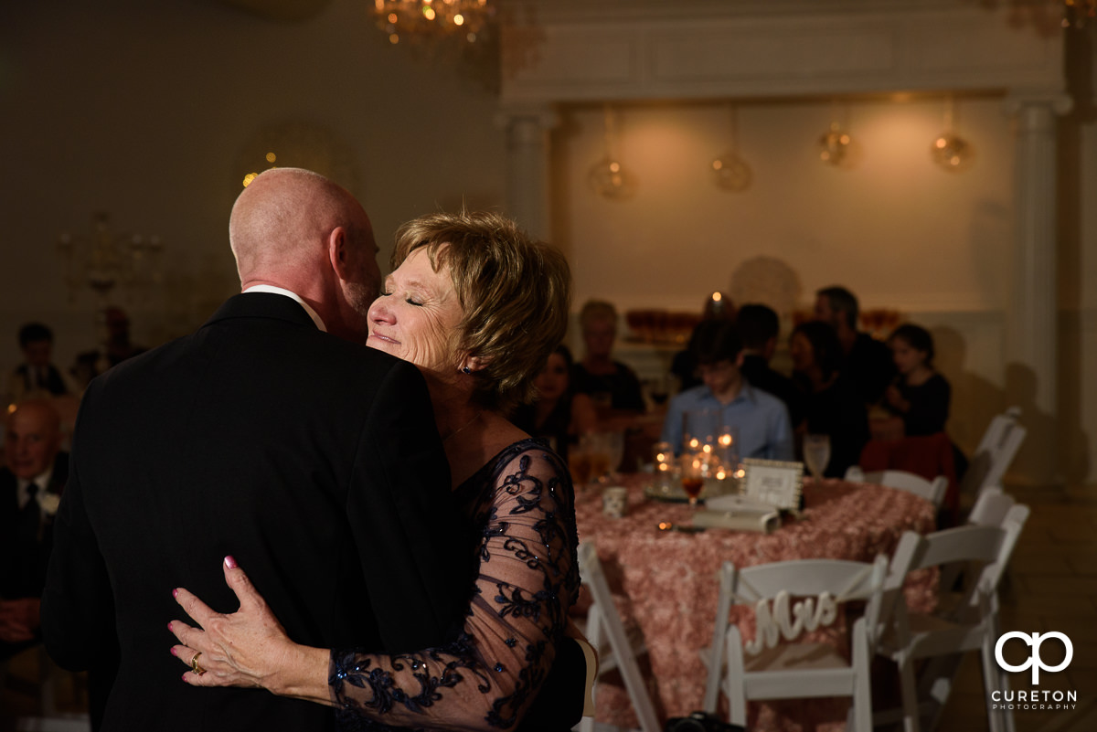 Groom hugging his mother after they share a dance at the reception.