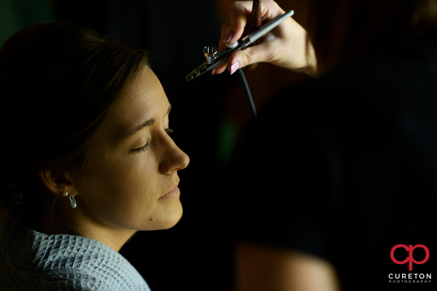 Bride having airbrushed makeup applied.