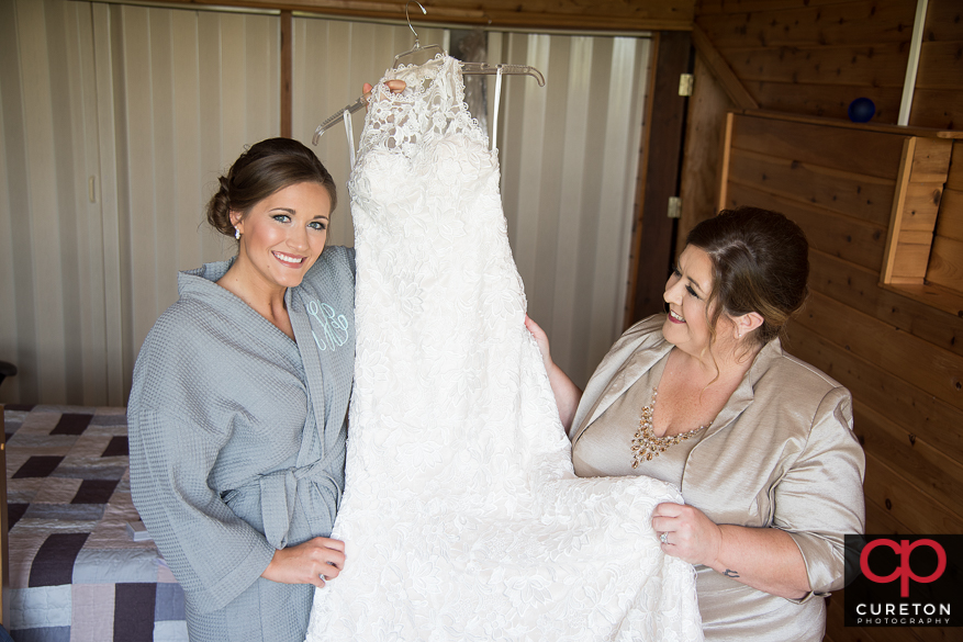 Bride and mother looking at her dress.