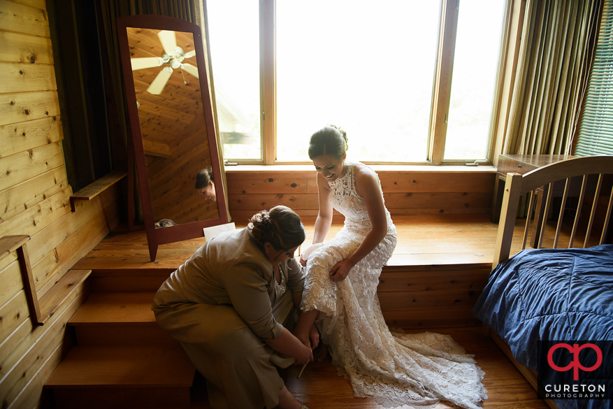 Bride's mom helping her into the dress.