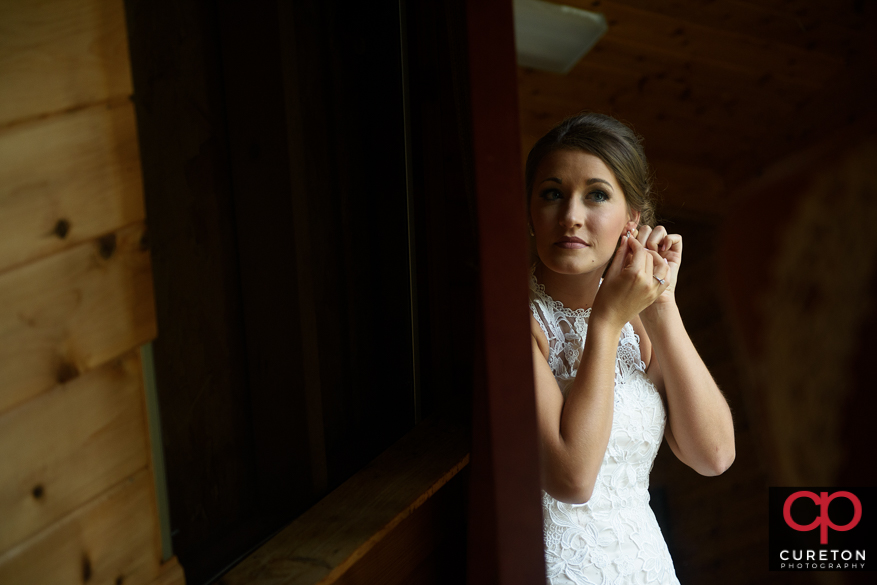 Bride putting on her earrings.