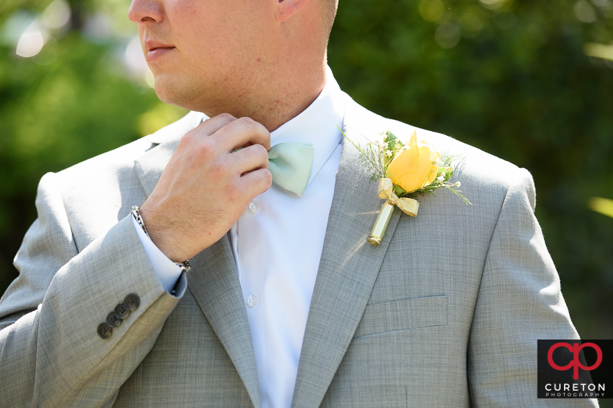 Groom adjusting his tie.