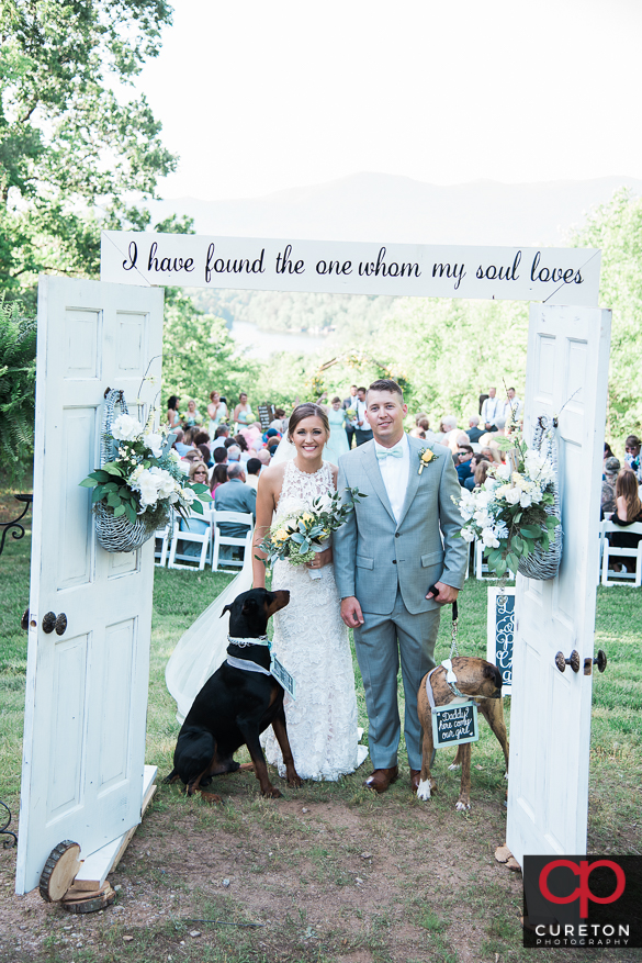 Bride and groom walk back down the aisle with their dogs.