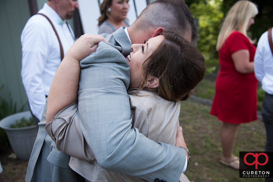 Mother of bride hugging the groom.