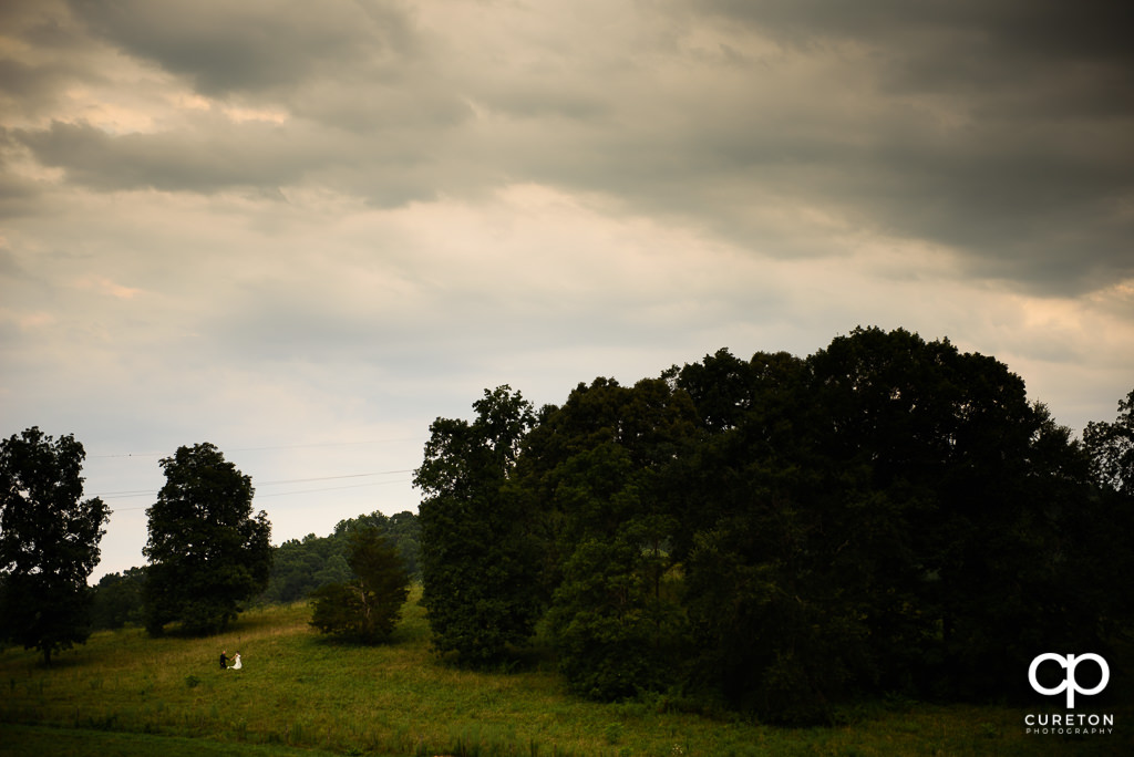 Bride and Groom walking up a hill after their wedding at South Wind Ranch in Travelers Rest SC.