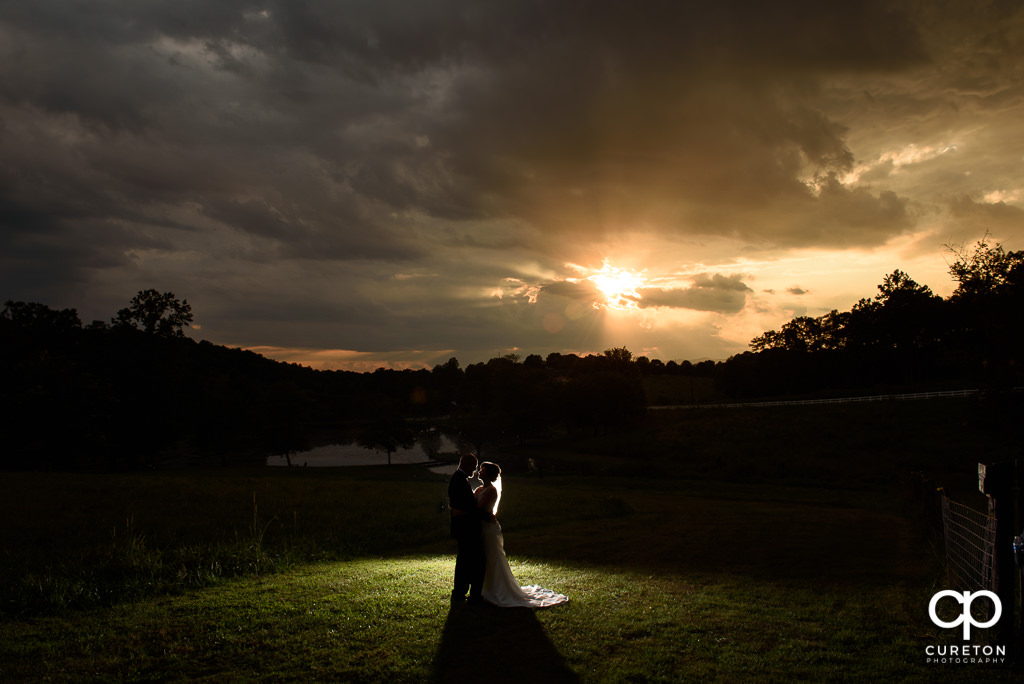 Bride and groom silhoueet at sunset after their wedding at South Wind Ranch in Travelers Rest SC.