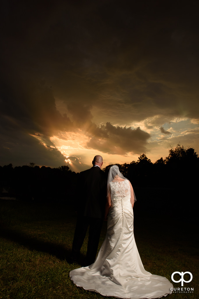 Married couple staring into the sunset after their wedding.