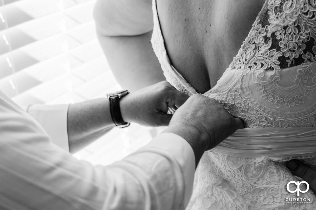 Bride getting help into her dress.