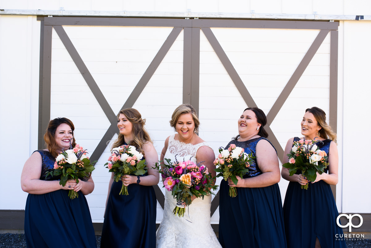 Bride laughing with her bridesmaids at her South Wind Ranch wedding in Travelers Rest,SC.