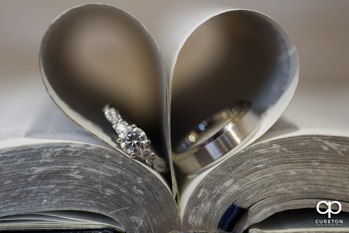 Wedding Rings in a Bible making a heart out of the pages.