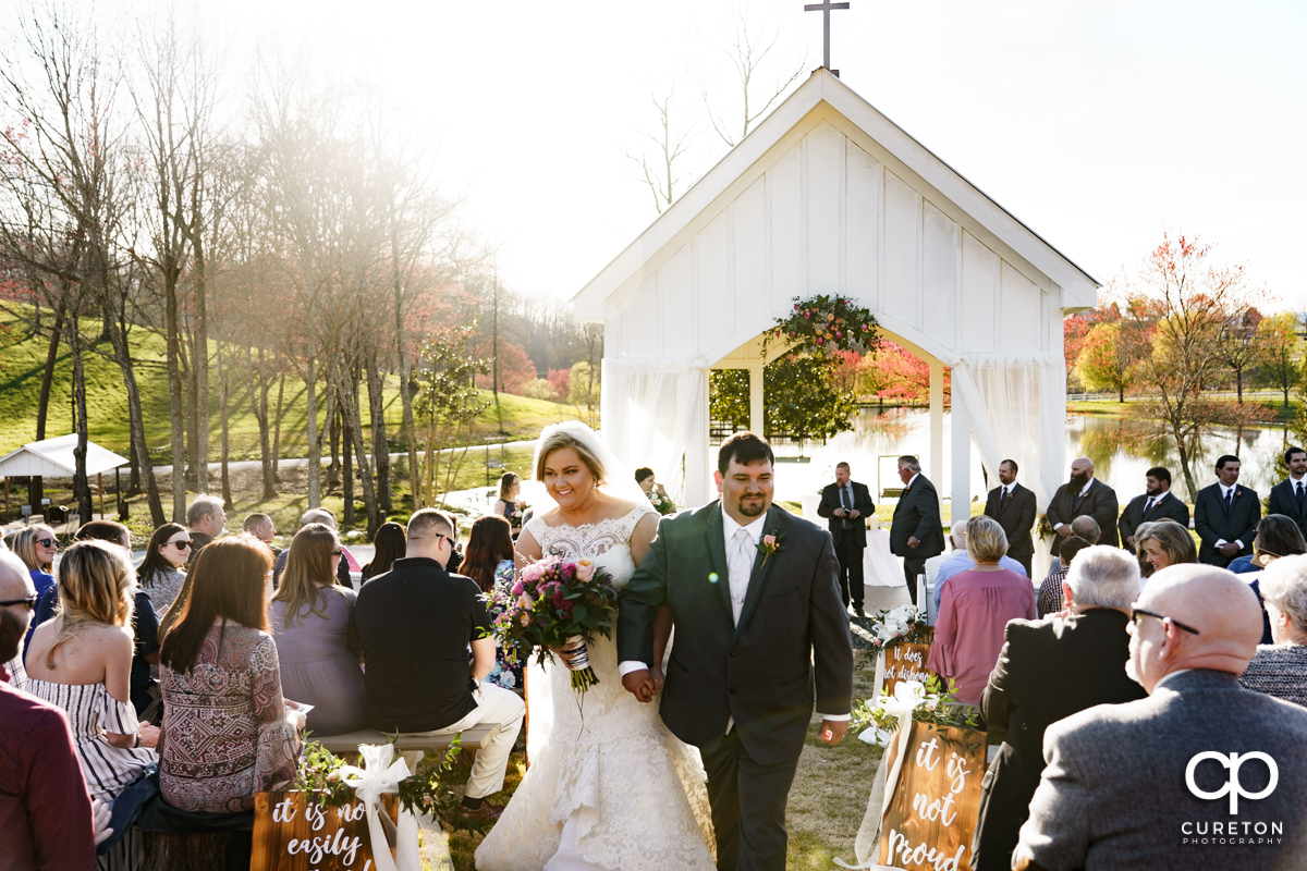 Bride and groom walking back up the aisle during their South Wind Ranch wedding in Travelers Rest,SC.