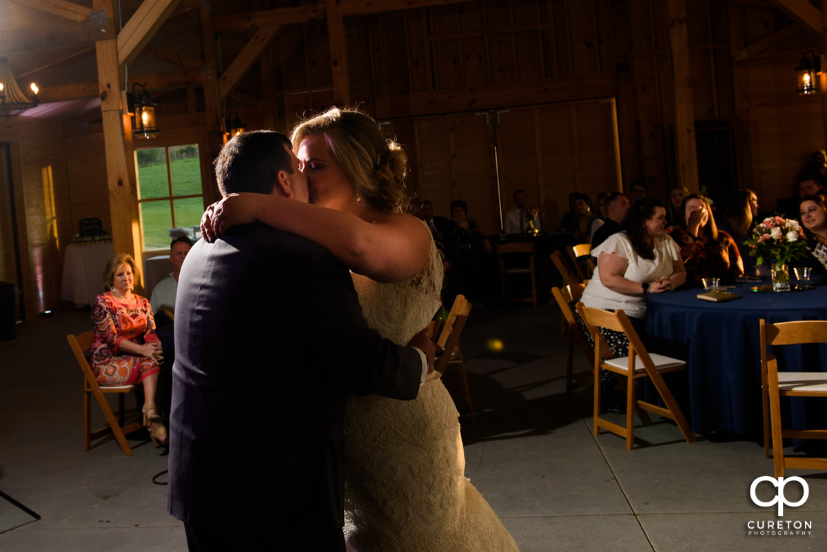 Bride and groom kissing during their first dance.