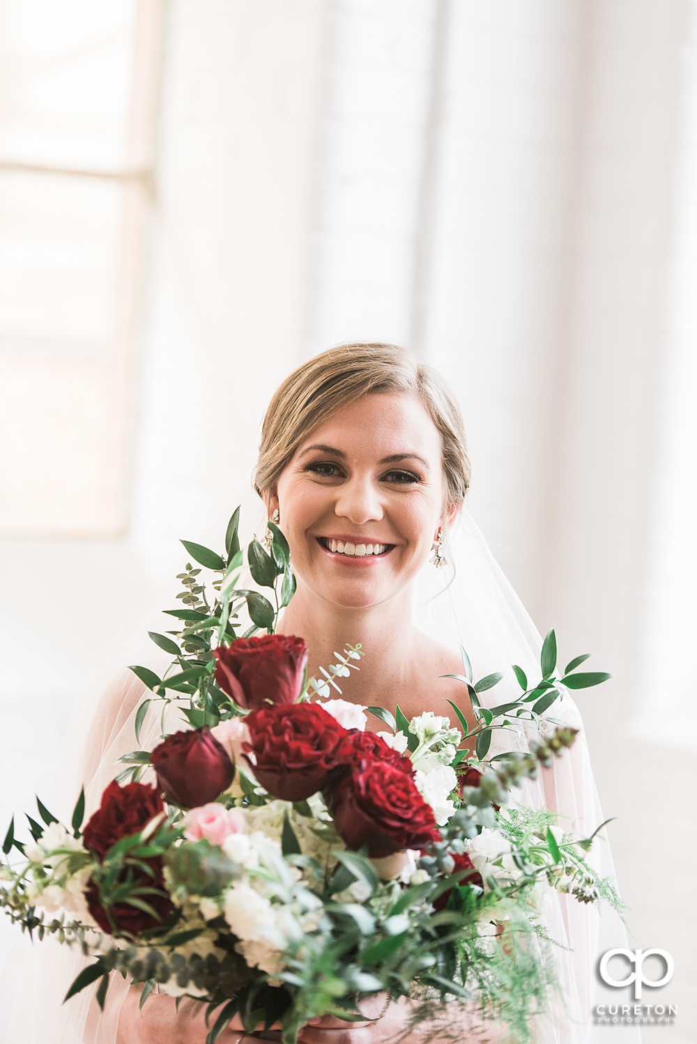 Bride smiling holding a beautiful bouquet by Culpepper Designs.