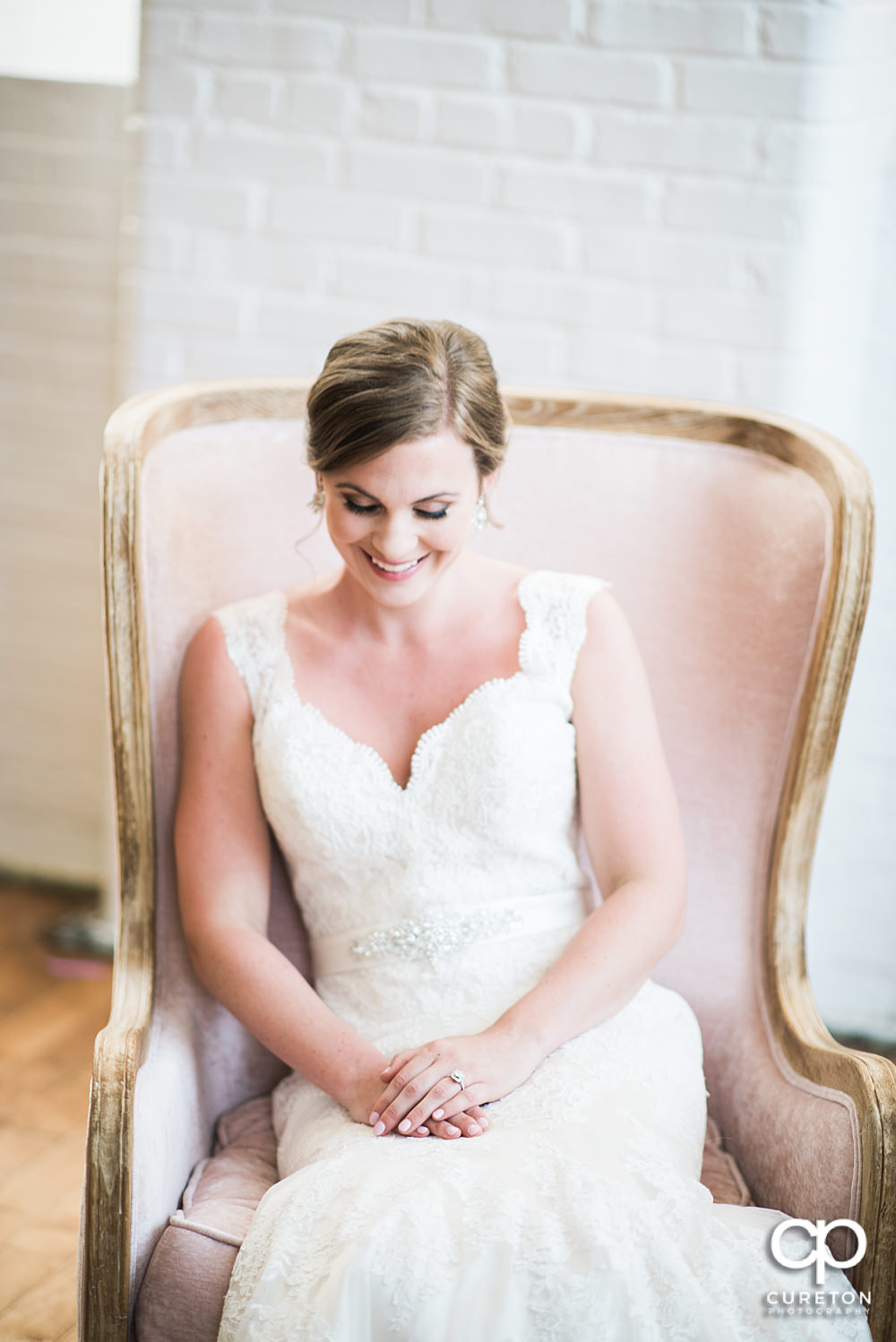 Bride sitting in a chair in the middle of the Southern Bleachery wedding venue.