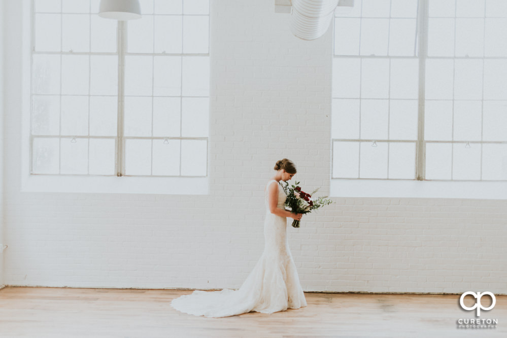 Bride smelling her bouquet during her bridal session at The Southern Bleachery wedding venue at the Taylor Mill.