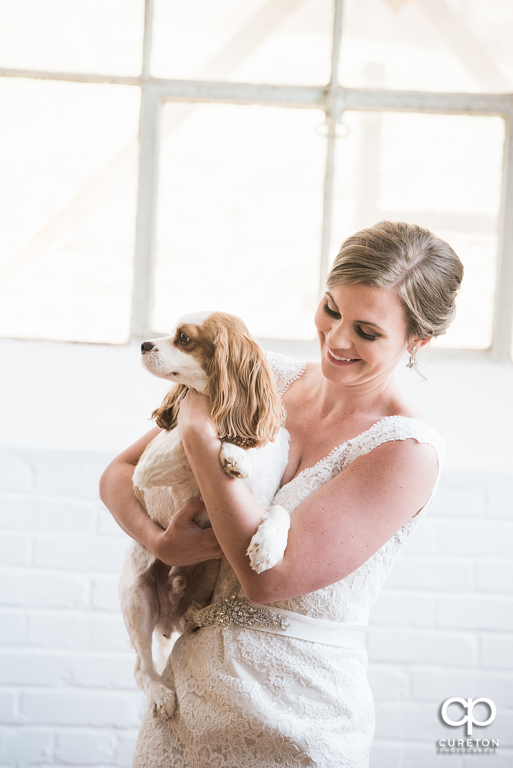 Bride and her dog laughing during her bridal session.