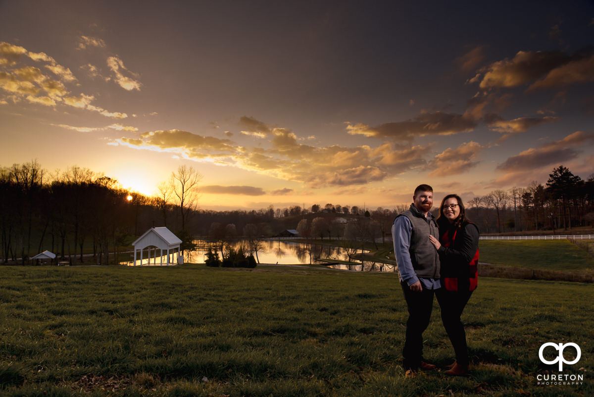 Future bride and groom at sunset in front of the chapel during a pre wedding South Wind Ranch engagement session in Travelers Rest,SC.