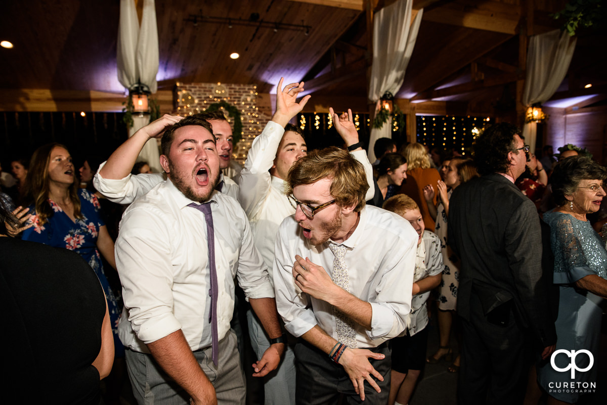 Groom and his friends singing on the dance floor at the wedding reception.