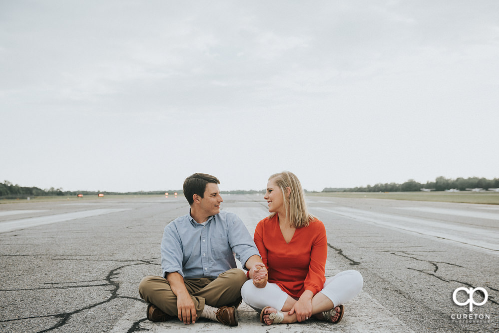 Engaged couple sitting on the runway during a Spartanburg Airport engagement session.