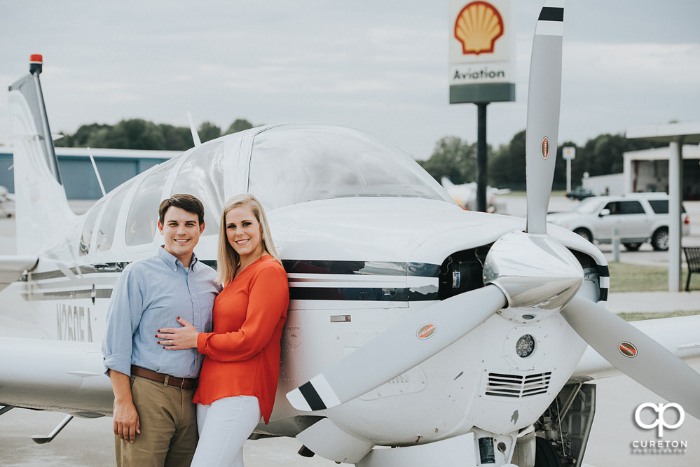 Engaged couple near a plane during a Spartanburg Airport engagement session.
