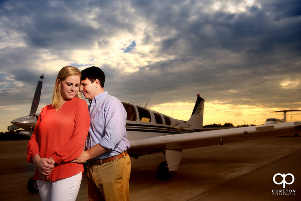 Bride and groom at sunset by a jet during a Spartanburg Airport engagement session.