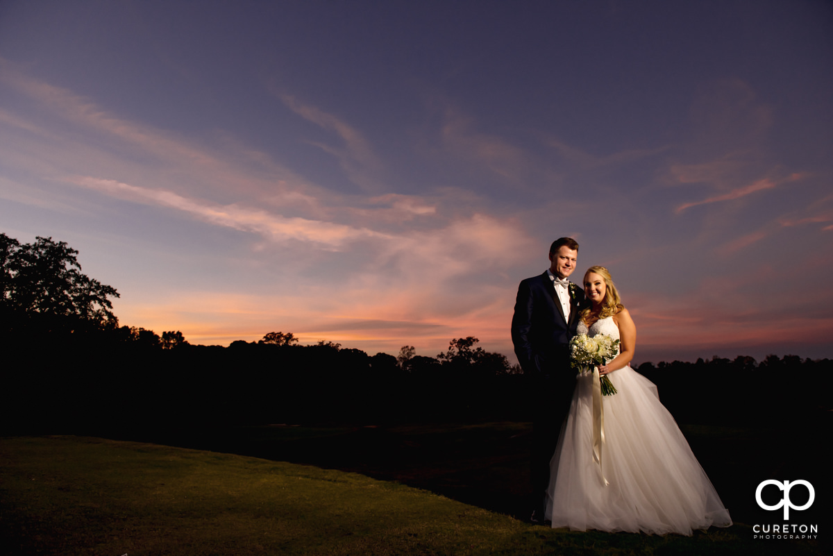 Bride and groom on the golf couse at sunset after their Spartanburg Country Club wedding.