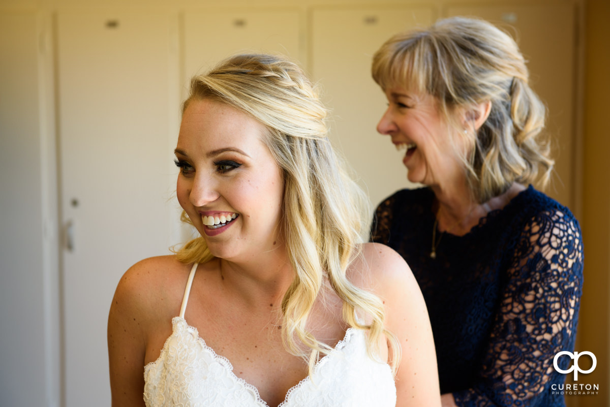 Bride laughing with her mother as she gets ready for her wedding day.