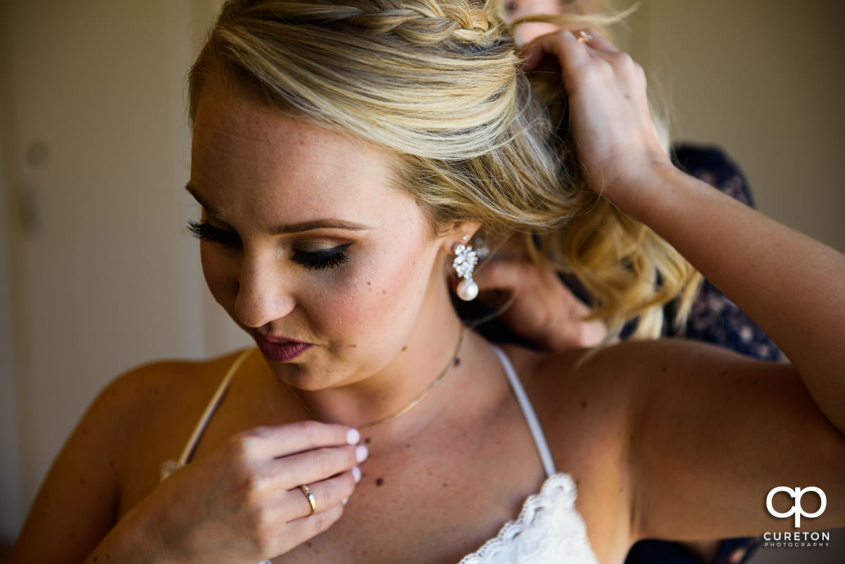 The Bride putting on her jewelry before her wedding ceremony