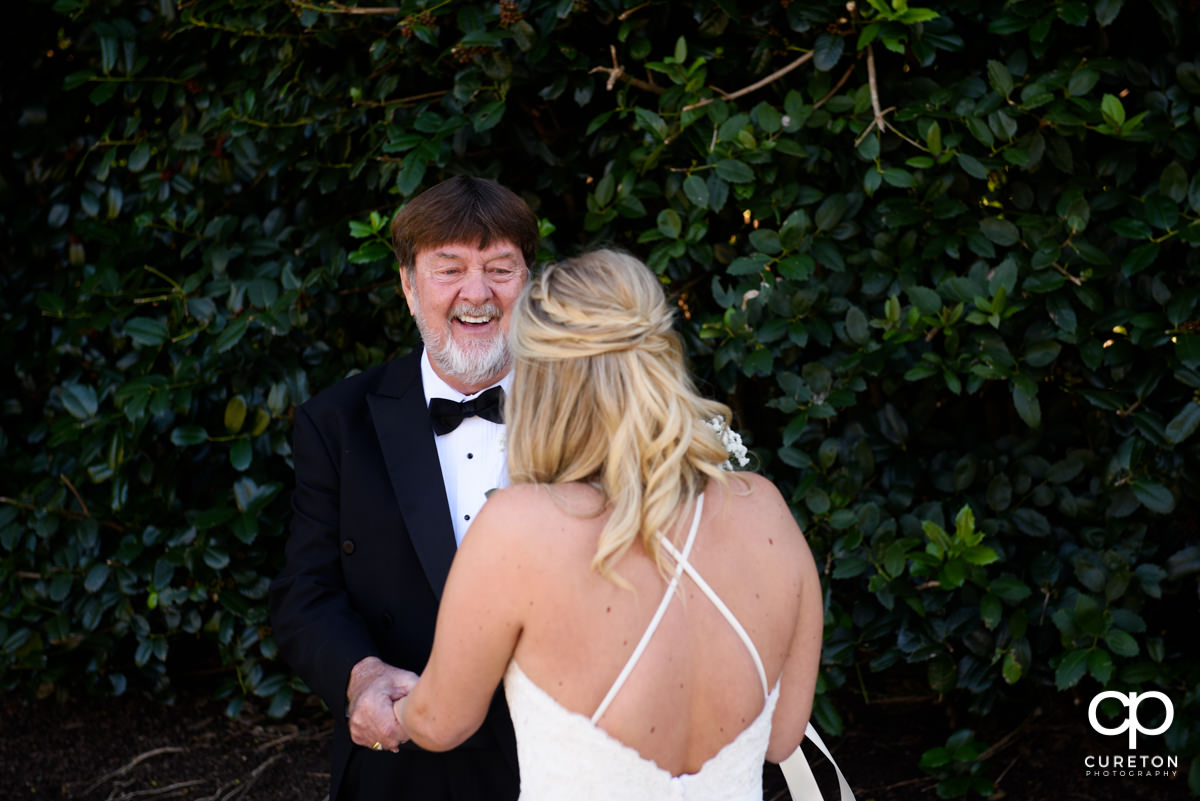 Bride's father with a huge smile on his face when he sees his daughter in her dress on the wedding day.