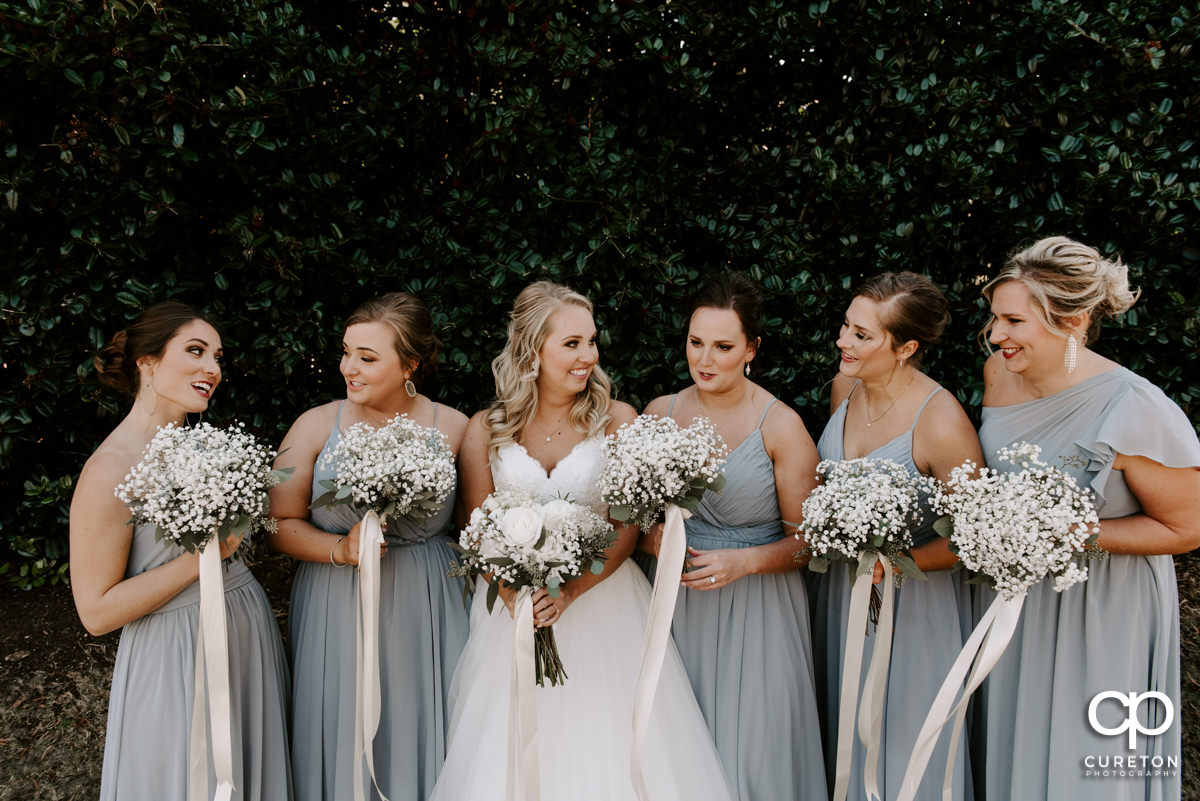 Bride laughing with her bridesmaids before the ceremony.