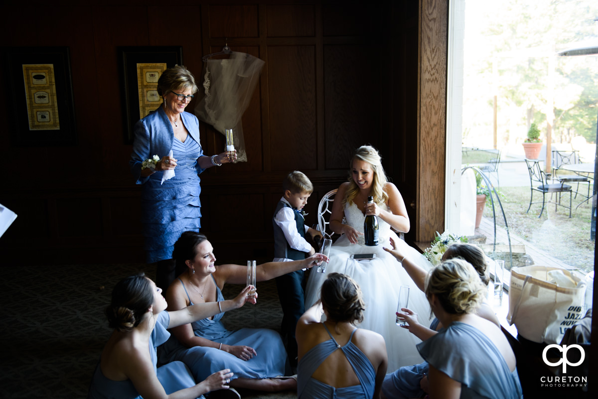 Bride sharing Champagne with her bridesmaids before she walks down the aisle.