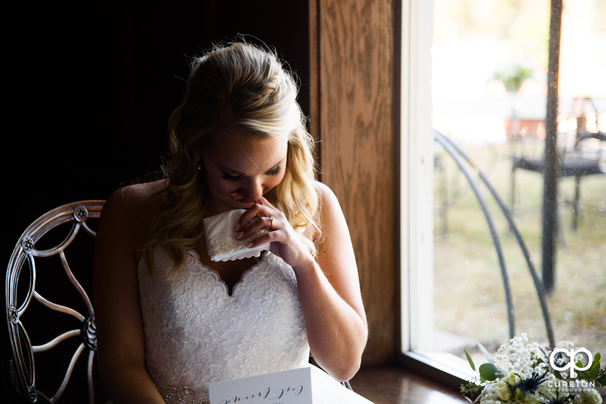 Bride tears up as she reads a letter from her husband.
