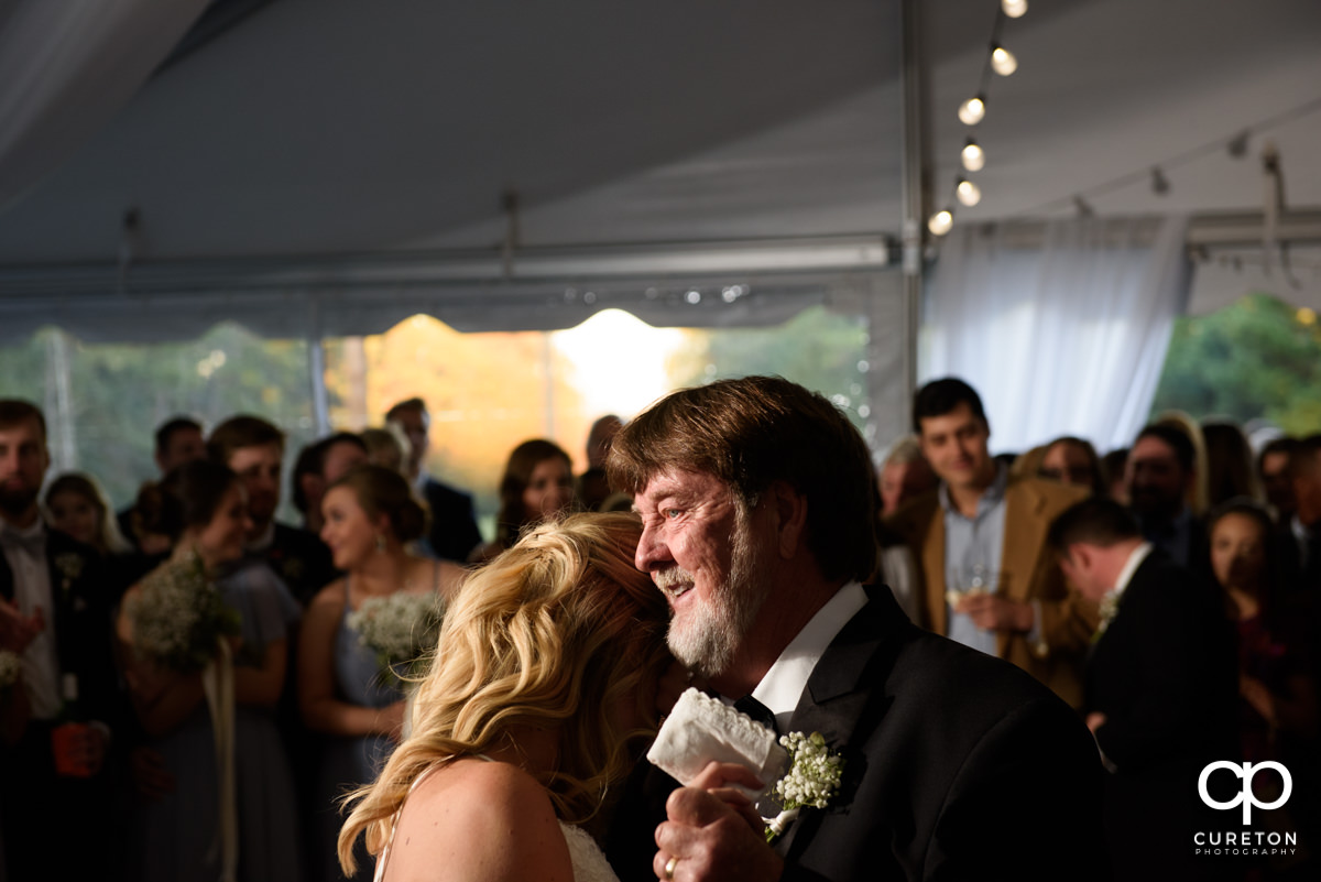 Bride and her father are sharing a dance at the reception.