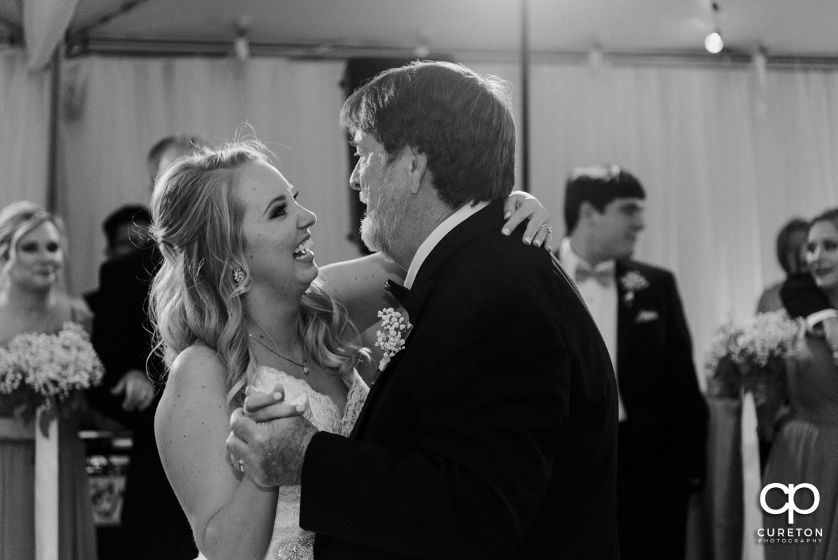 Bride and her dad laughing during a dance at the wedding reception.