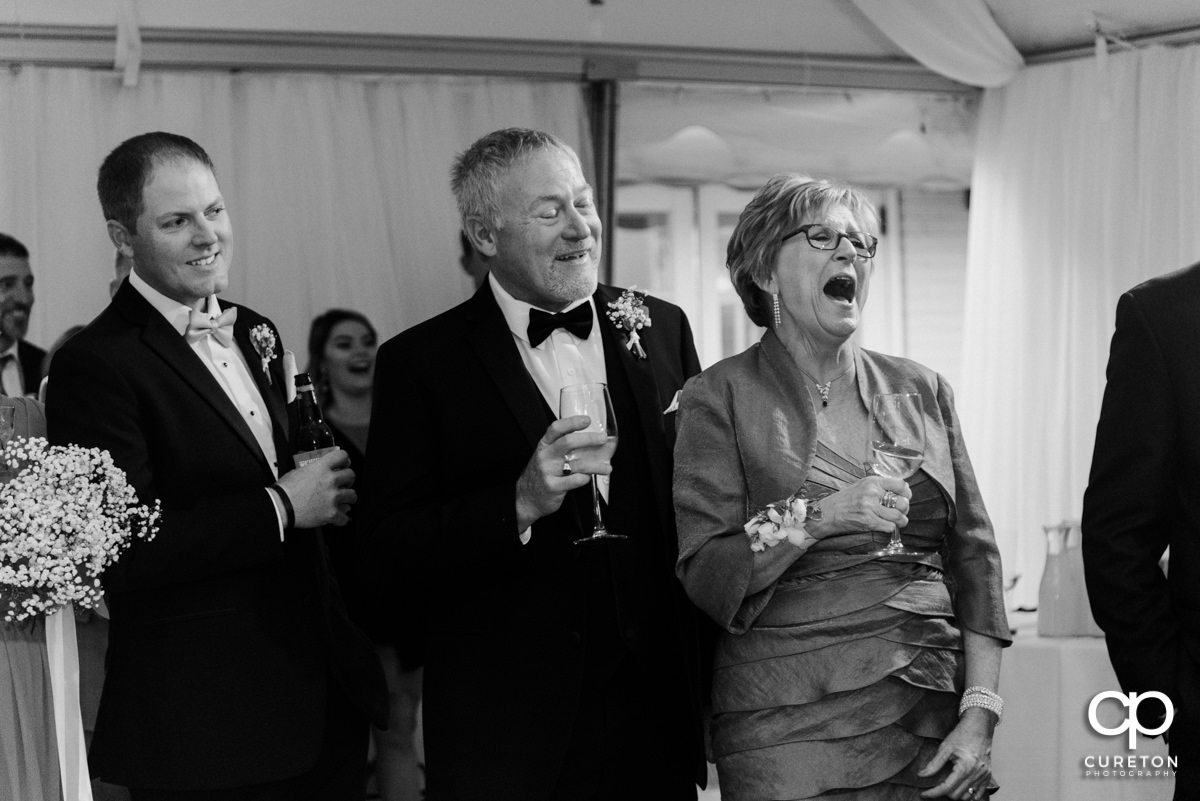 Wedding guests laughing during a speech.