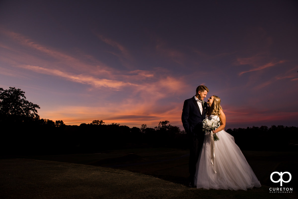 Bride and groom smiling at sunset at Spartanburg Country Club.