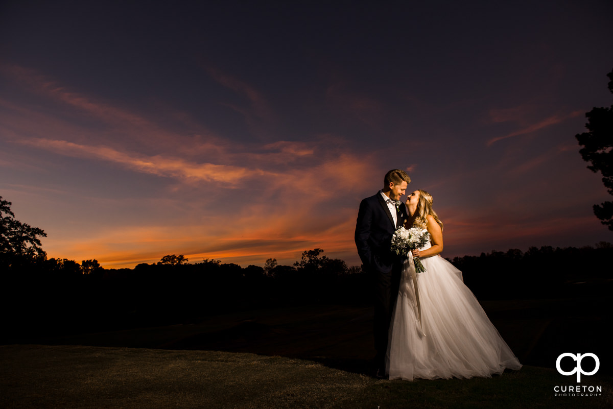 Bride and groom posing underneath an amazing sunset in Spartanburg.