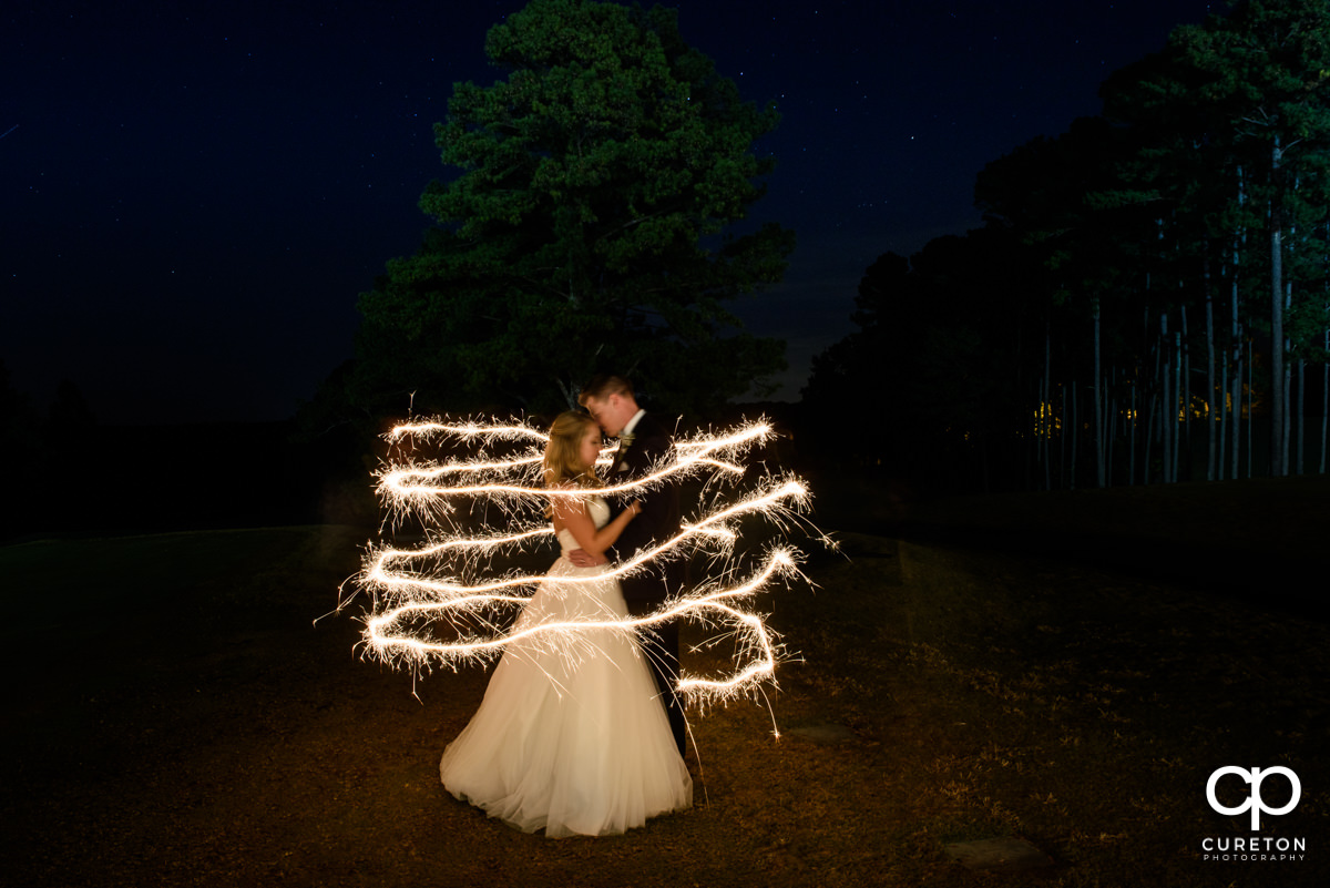 Creative photo of the bride and groom with sparklers.