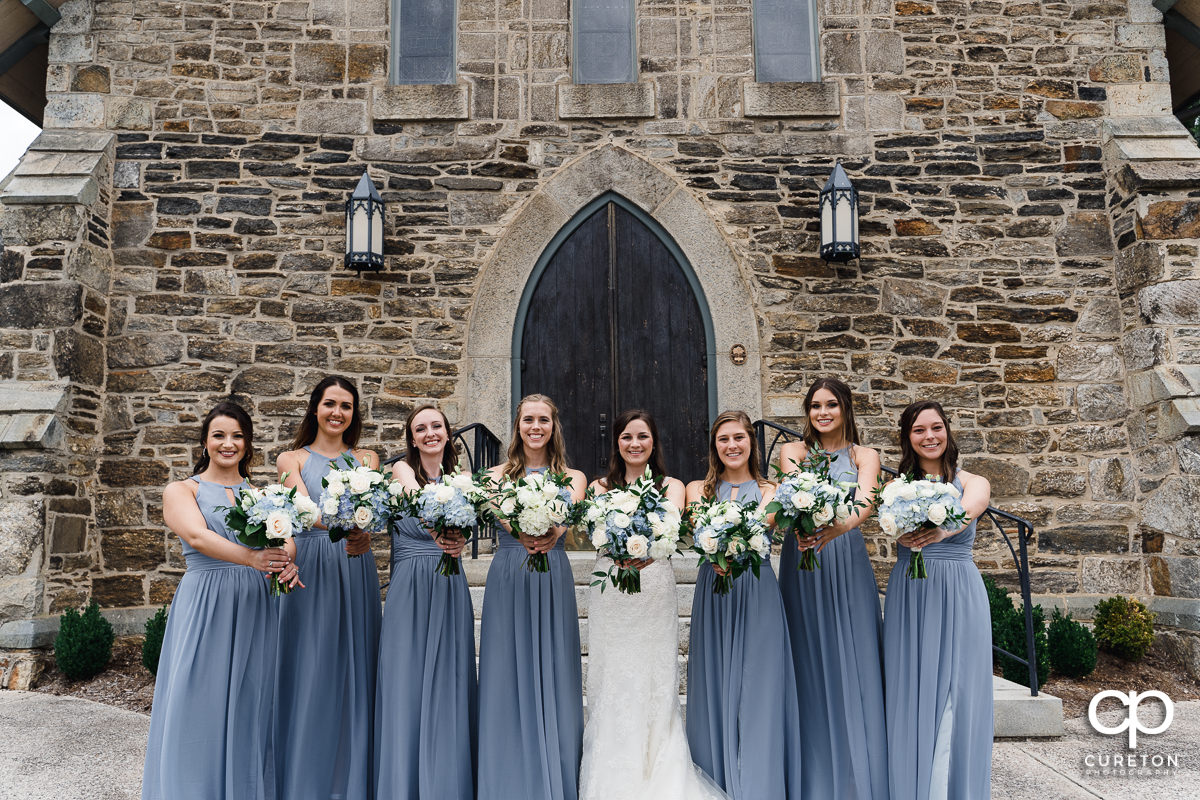 Bride and bridesmaids holding their flowers out.