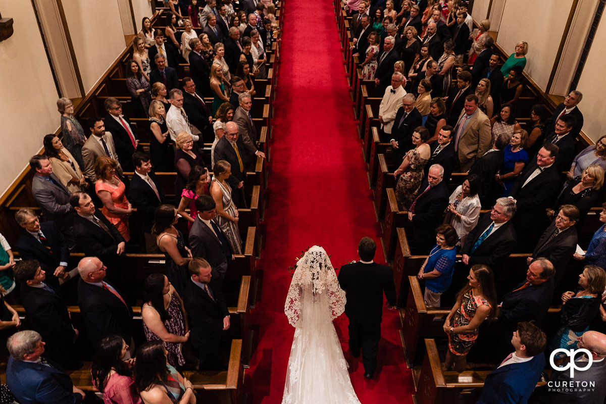 Bride and her father walking down the red aisle from above at her Spartanburg wedding.