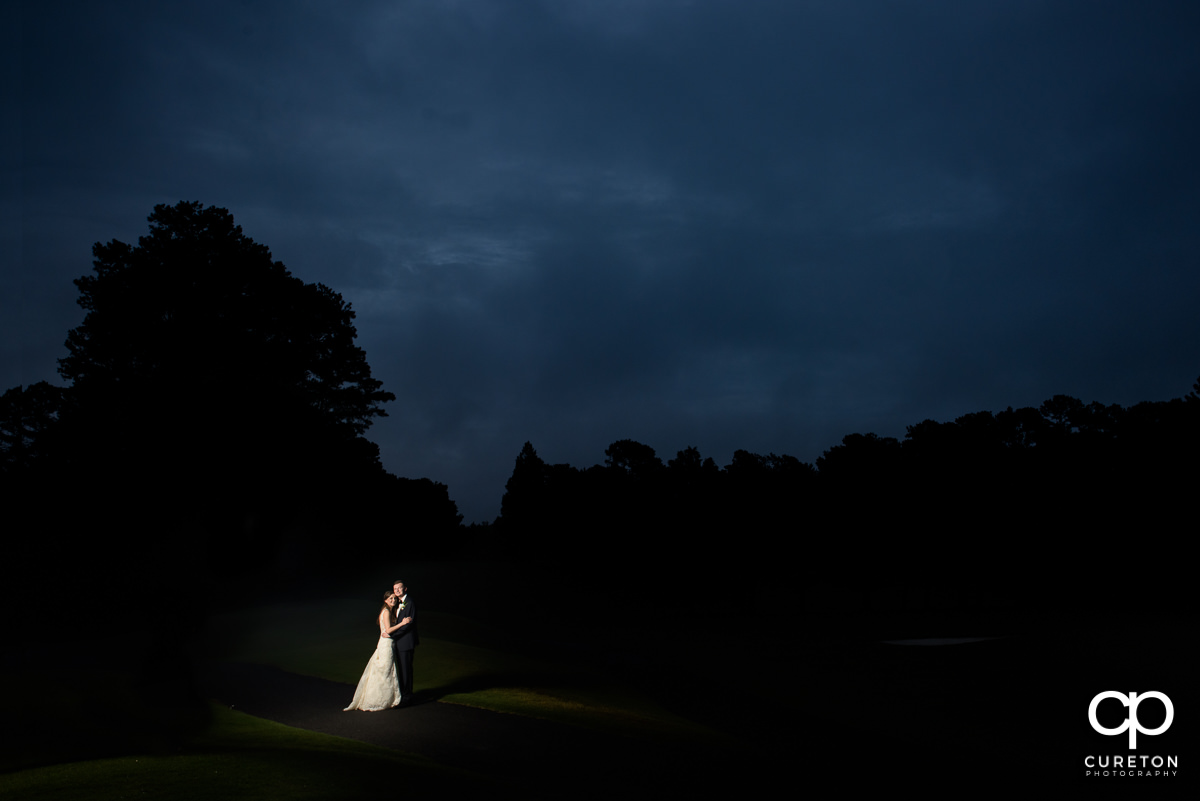 Epic shot of a bride and groom on the golf course at twilight at the wedding reception at Spartanburg Country Club.