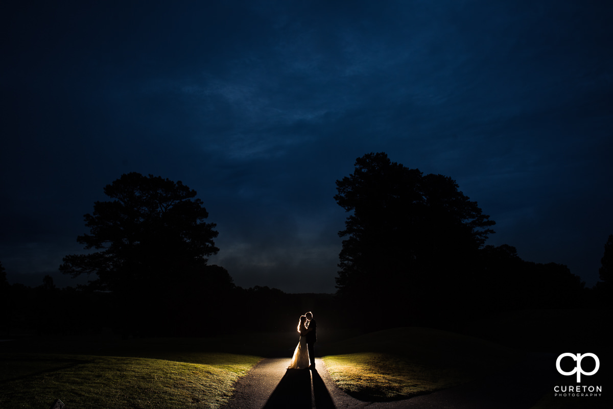 Bride and groom underneath a deep blue sky at night on the golf course at the wedding reception at Spartanburg Country Club.