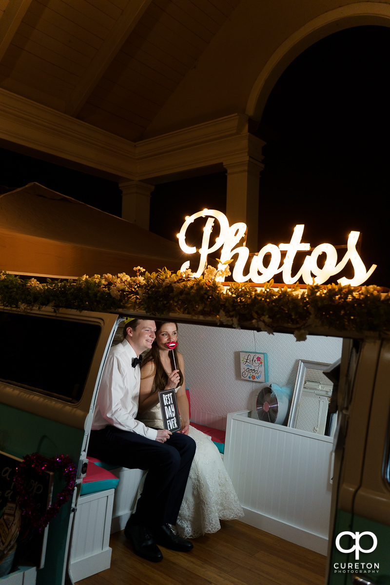 Bride and groom enjoying a photo booth in a Volkswagen bus.