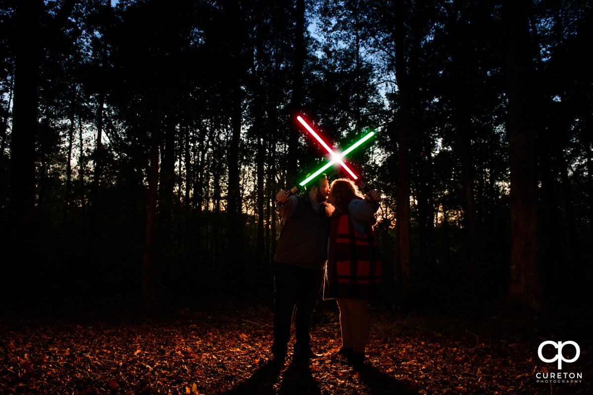 Bride and groom crossing lightsabers at their Star Wars engagement session.