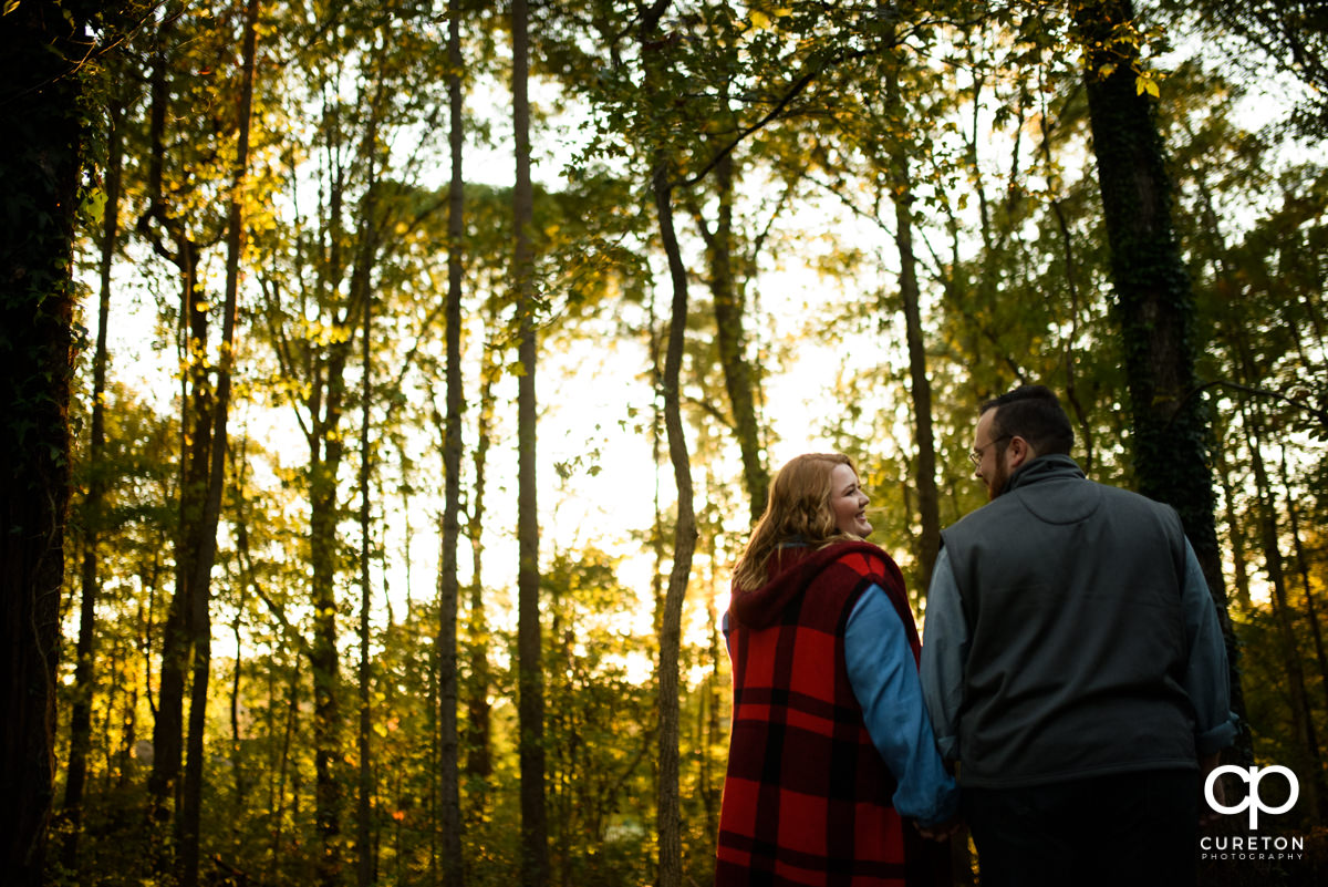Engaged couple walking though the forest.