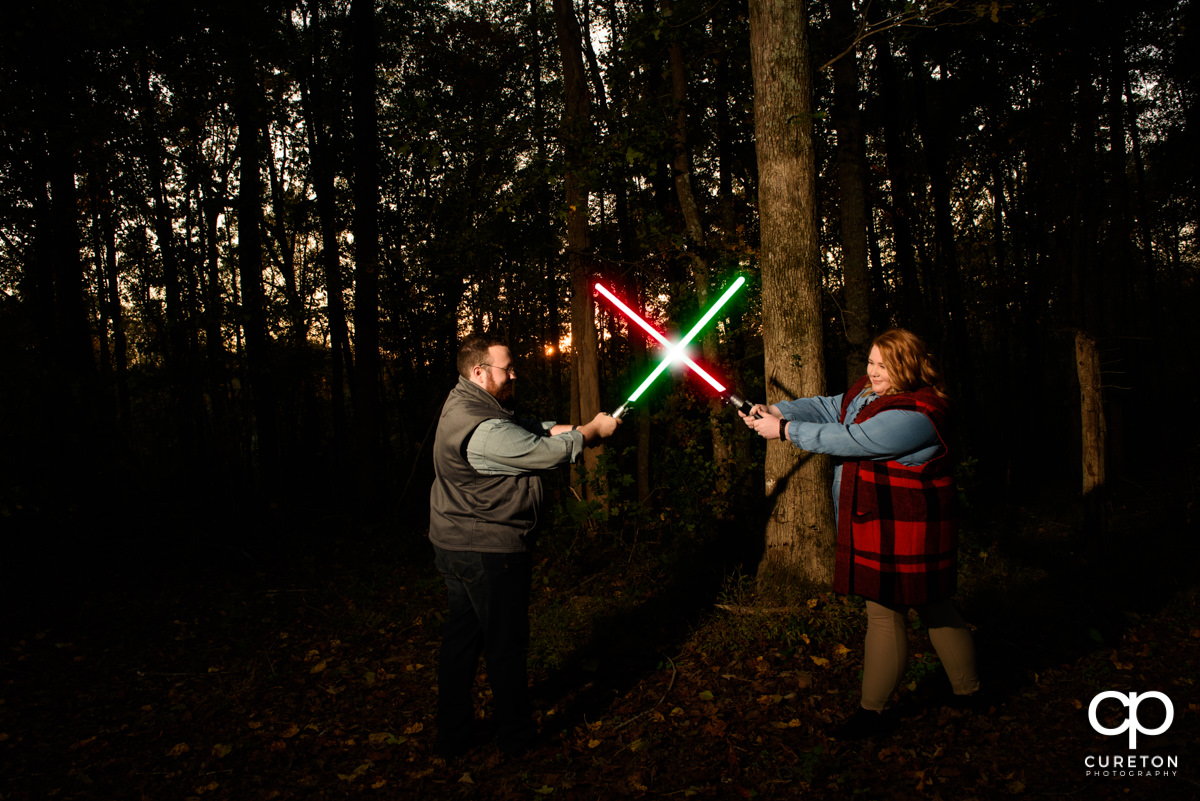 Future bride and groom battling with lightsabers at their Star Wars themed save the date session.