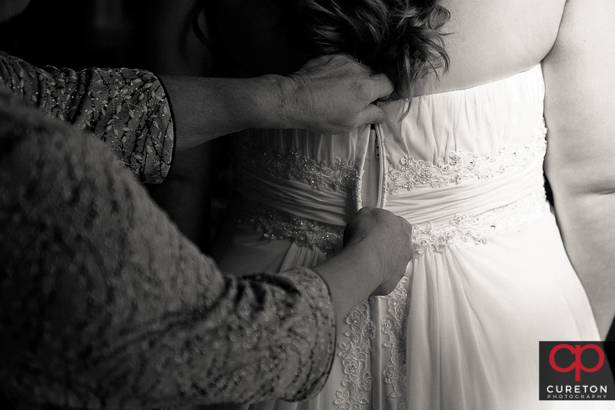 Bride putting on her wedding dress.