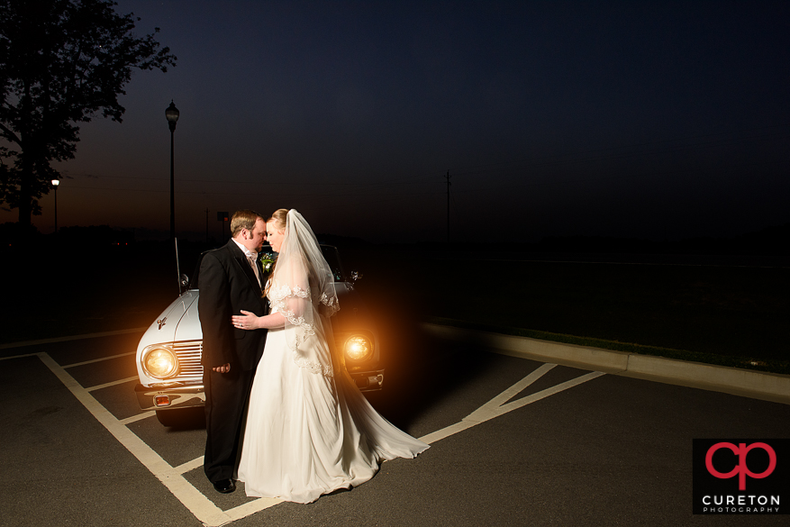 Bride and groom with a vintage car.