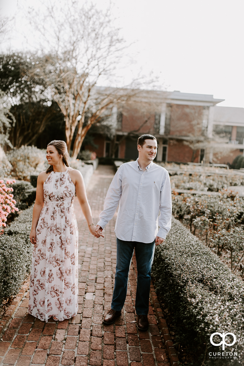Future bride and groom in a rose garden in Greenville,SC during an engagement session.